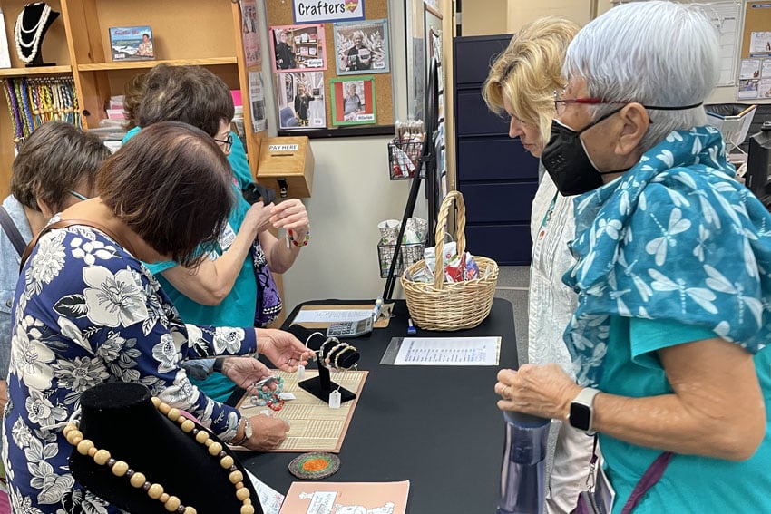 Photo: Seniors from Hui at Manoa inspect handmade jewelry at the CSC