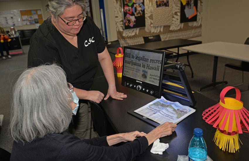 Photo: CSC staff using a magnifier