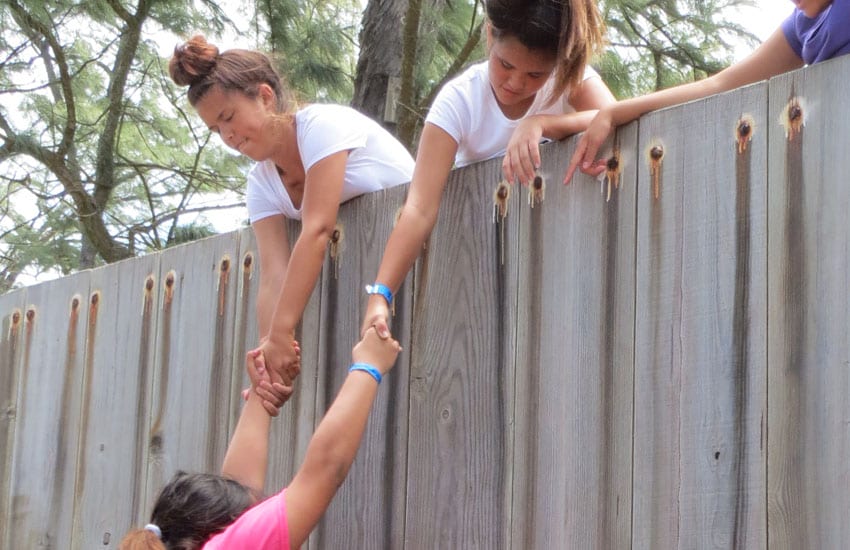 Photo: Camp participants pull a student up the wall